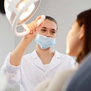 female-dentist-adjusting-lamp-KJSVFBU.jpg